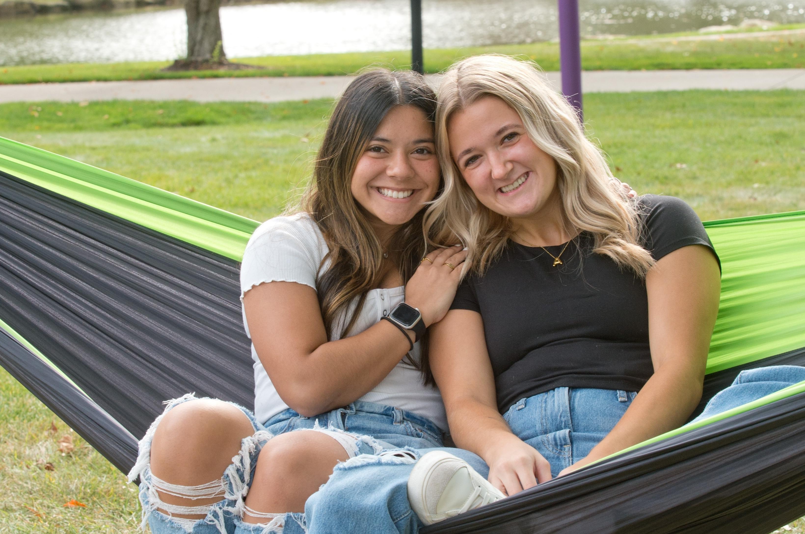 Mount Union students smiling on a hammock by the lakes.